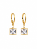 Close-up of gold-tone hoop earrings with square clear crystal pendants