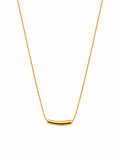 Close-up of a gold-tone bar necklace on a white background